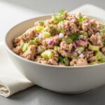 Healthy tuna salad recipe in white bowl with fresh dill celery and creamy Greek yogurt dressing