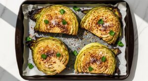 Best roasted cabbage steaks with crispy caramelized edges parsley and parmesan on baking sheet